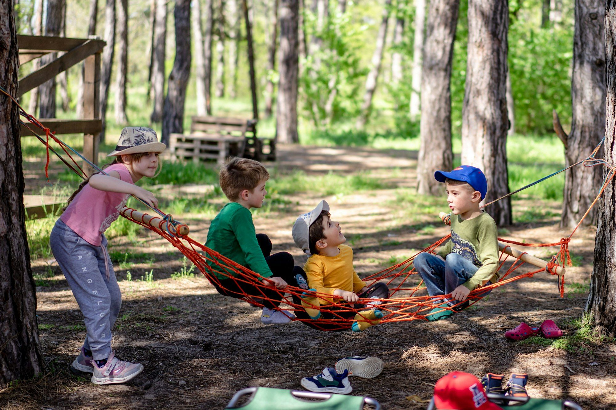 Children relaxing in a hammock in a pine forest
