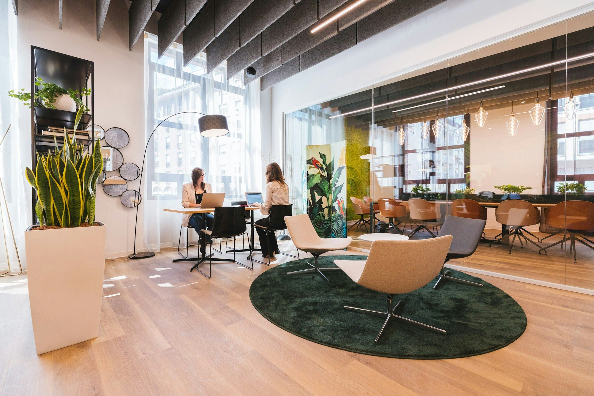 A bright, sunlit workspace with desks and lounge chairs
